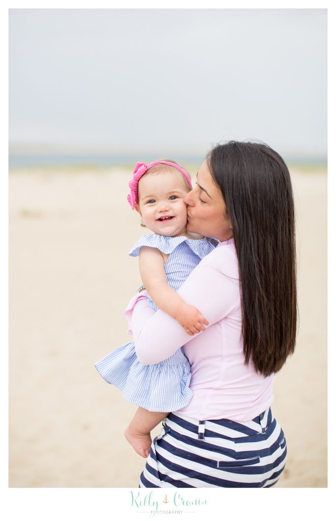 A mother kisses her baby's cheek during their family photographs in Cape Cod. 