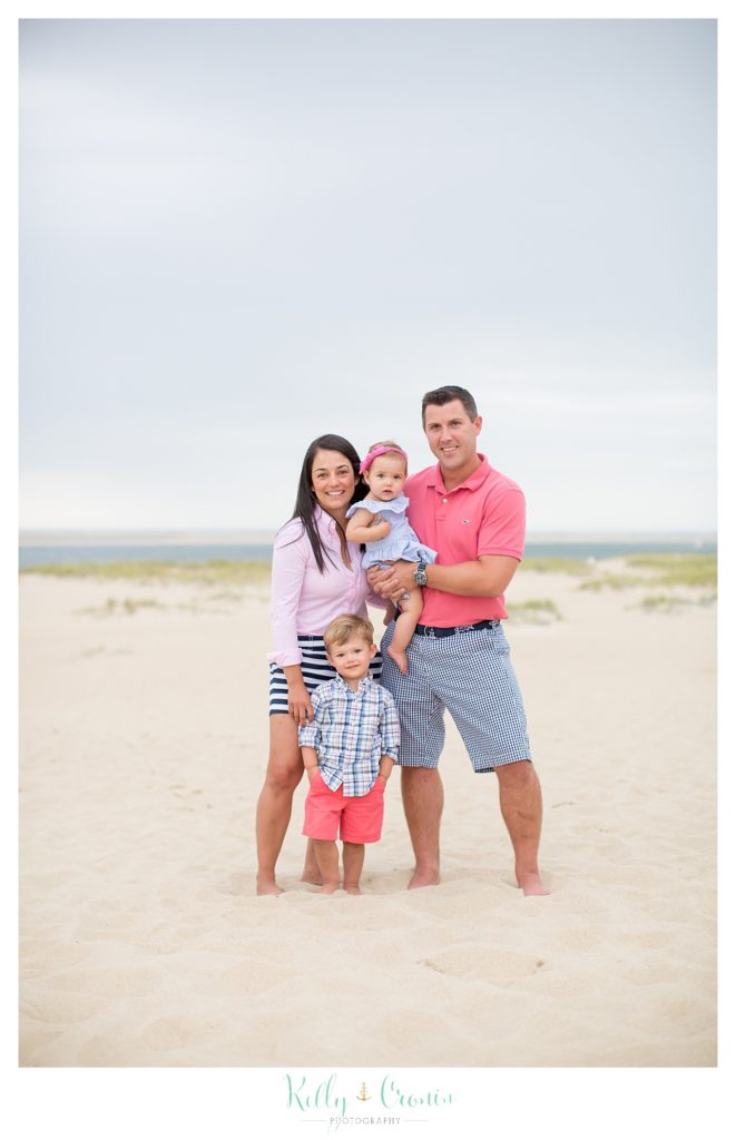 A family stands together, posing for their family photographs in Cape Cod. 