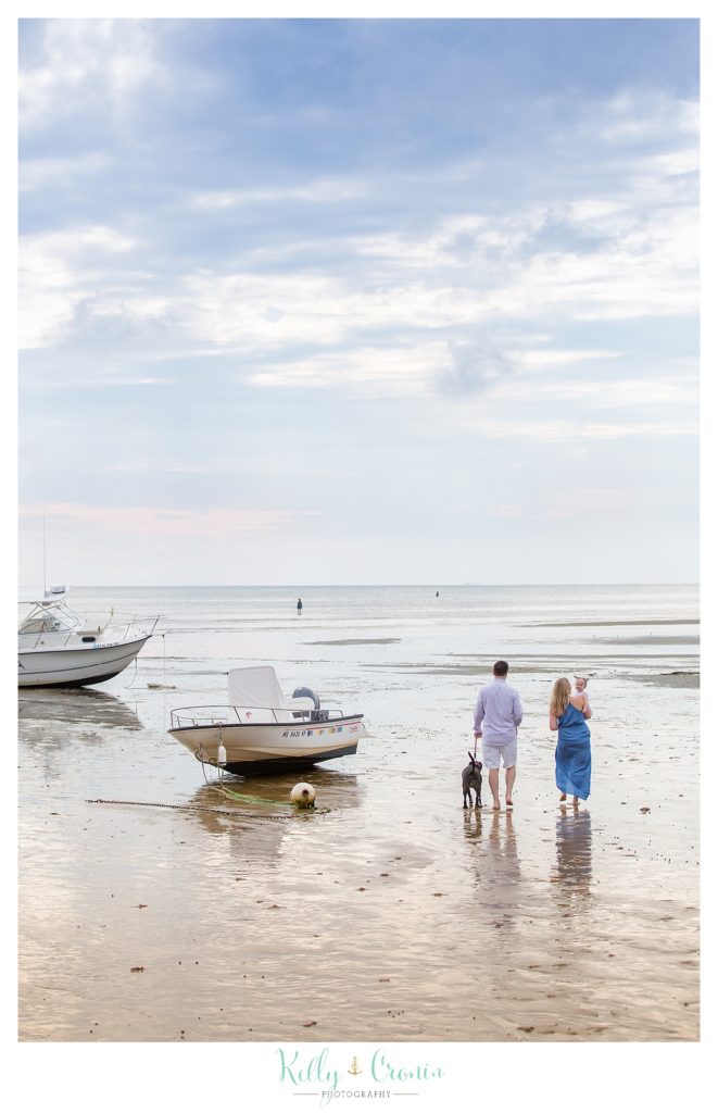 A family walks in the water for their beach photos. 