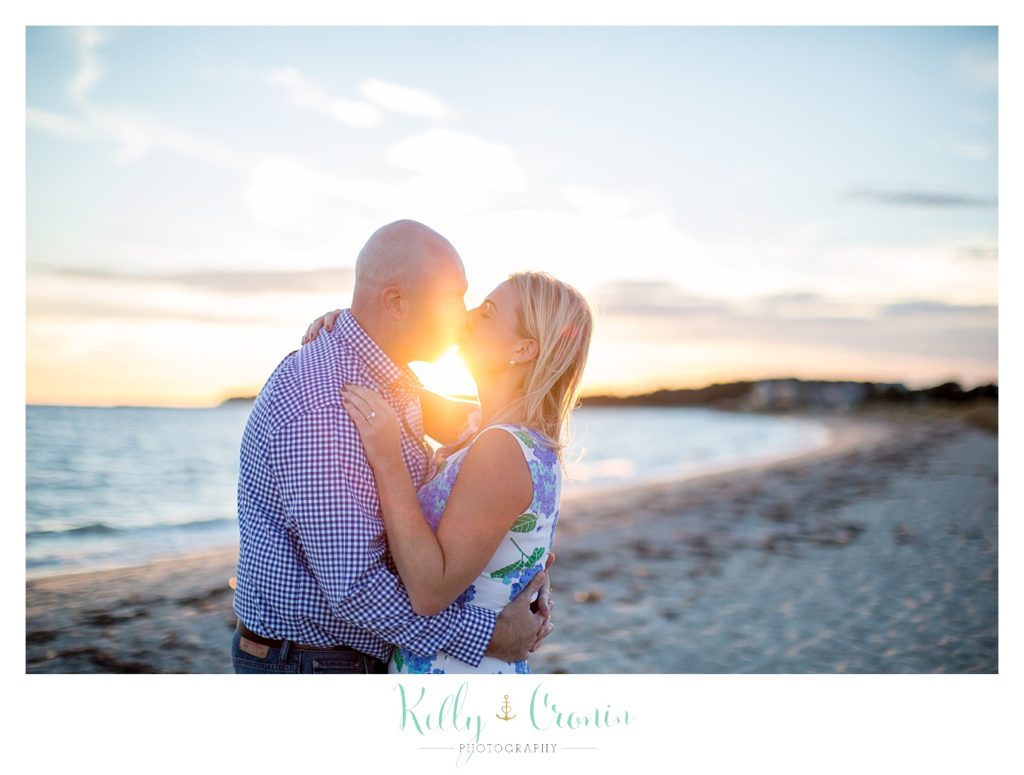 A couple kiss while the sun shines between them | Engagement Session In Cape Cod