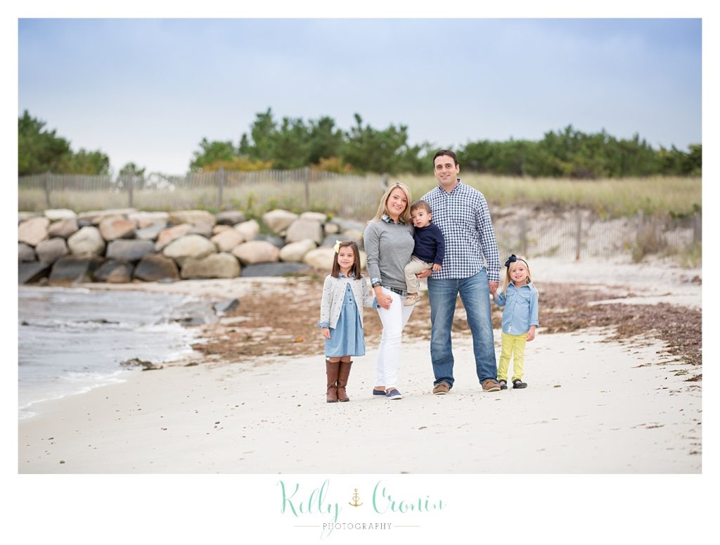 A family photographer captures a family standing together. 