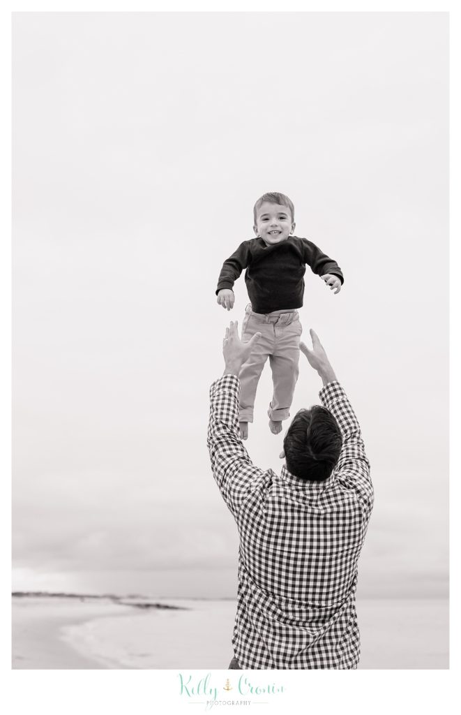 A man throws his son into the air. 
