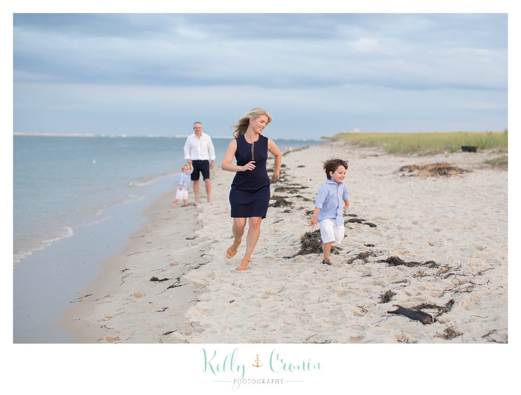 A family is walking along the shore line. 