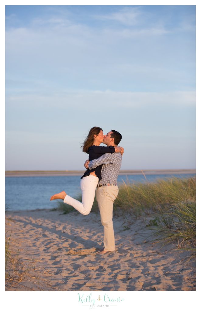 A couple kiss while celebrating their Cape Cod engagement. 