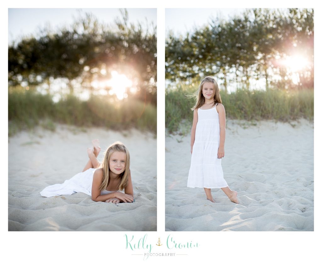 A girl lays in the sand during Family Pictures In Cape Cod. 