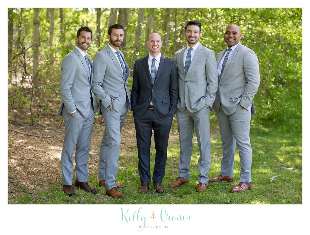 A grooms stands with his groomsmen. 