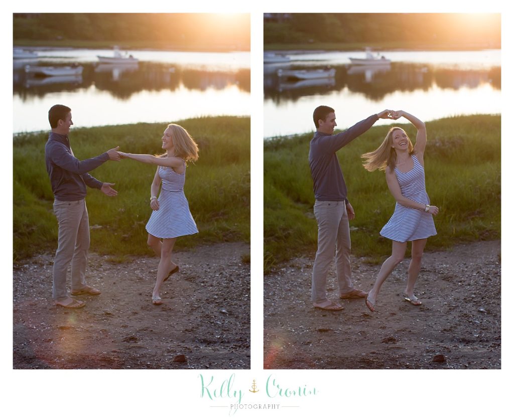 An engaged couple dance at sunset on the beach. 