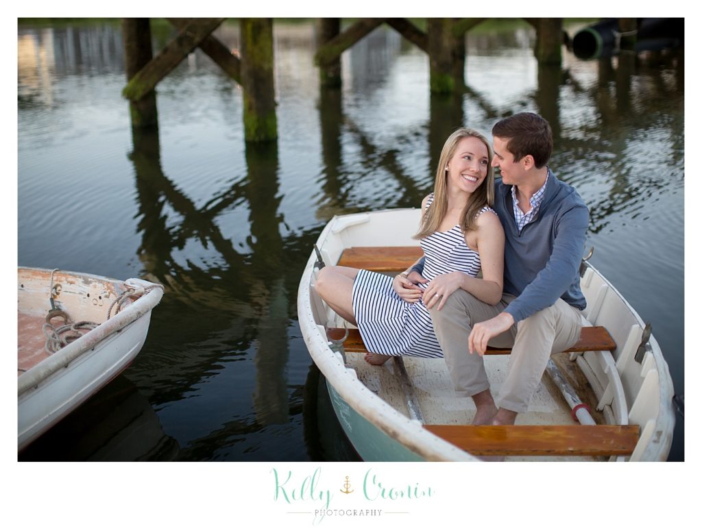An Engagement Photographer captures a couple snuggling in a boat. 