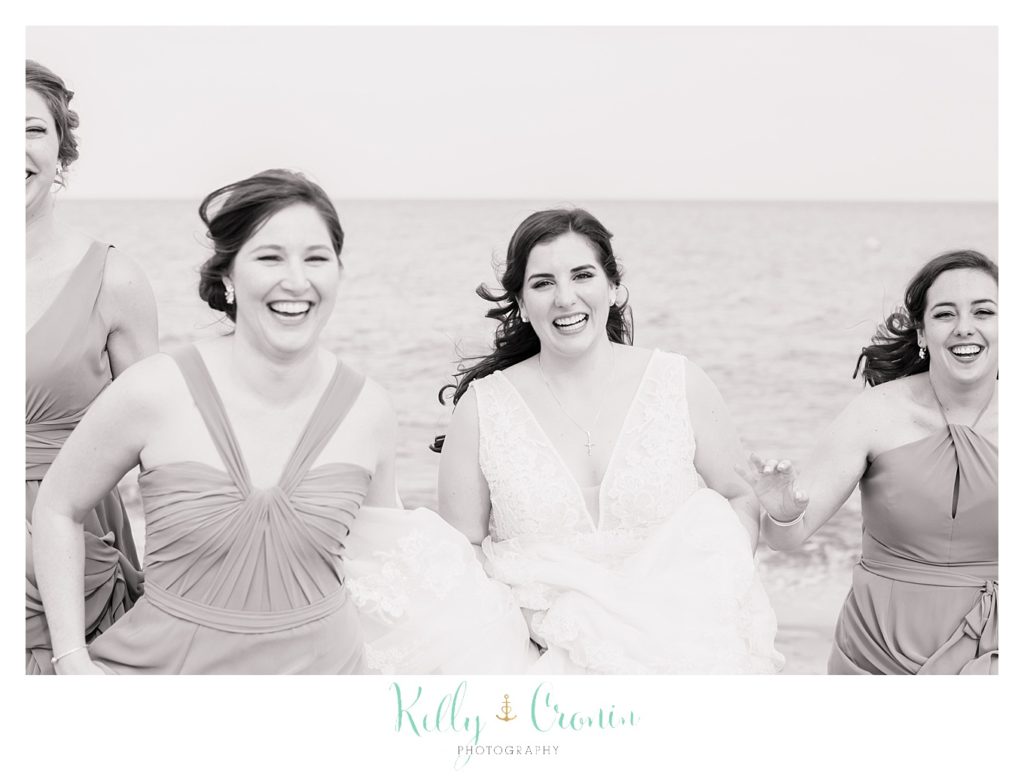 A bride laughs with her bridal party. 
