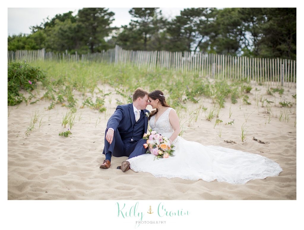 A bride and groom share a quiet moment on the beach together. 