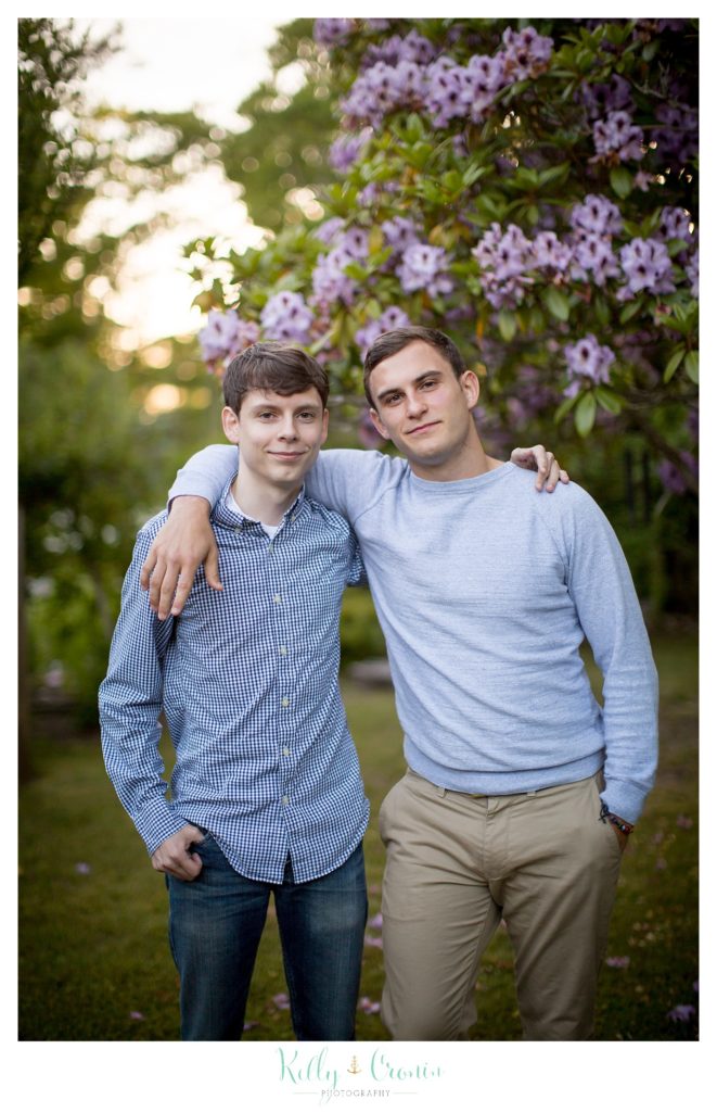 A man puts his arm around his brother for a photo. 