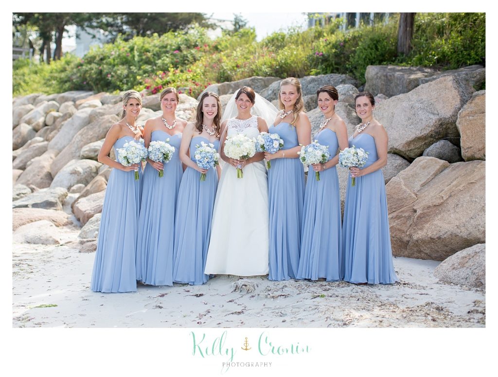 A bridal party stands on the beach on Cape Cod. 