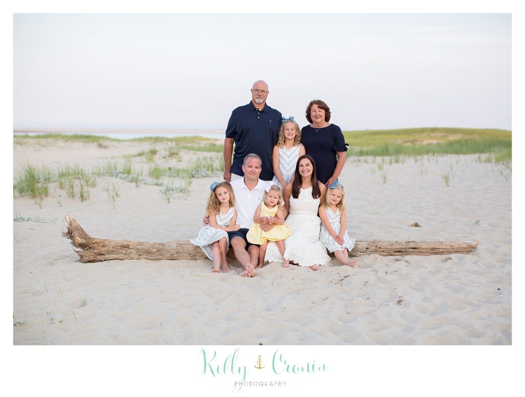 A family sits together during a seaside photography session. 