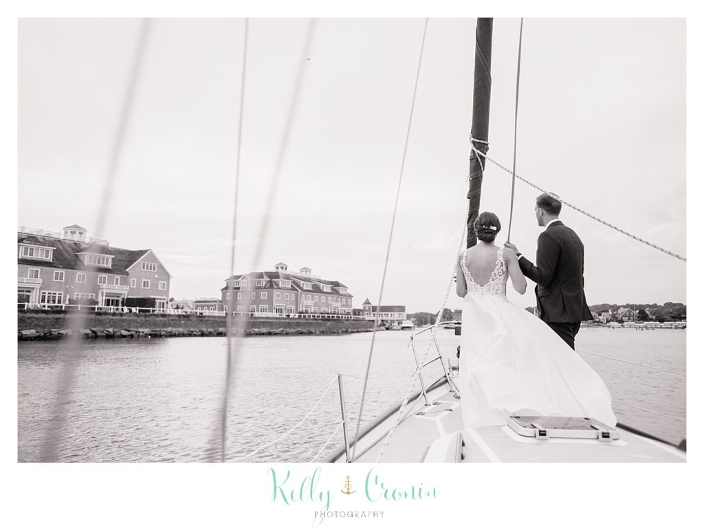 A bride and groom sail on a boat. 