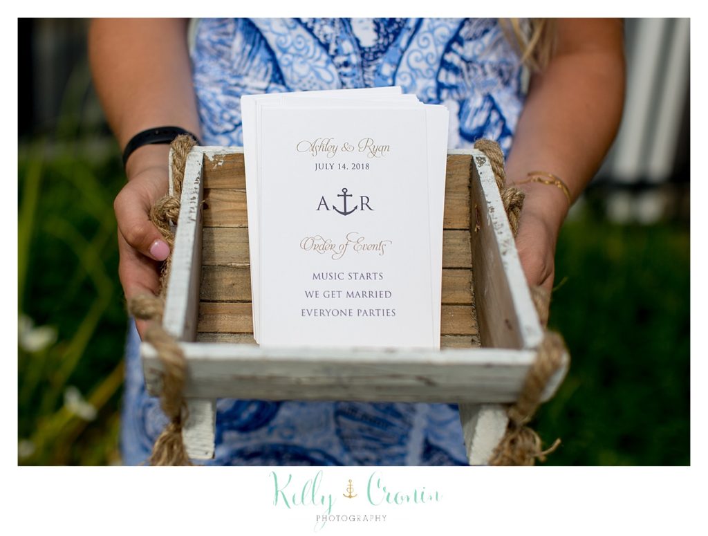 A woman holds a box with a wedding invitation inside. 