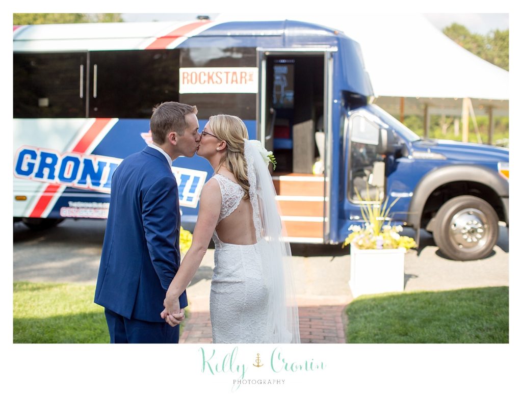 A couple share a kiss in front of the Gronk Part Bus. 
