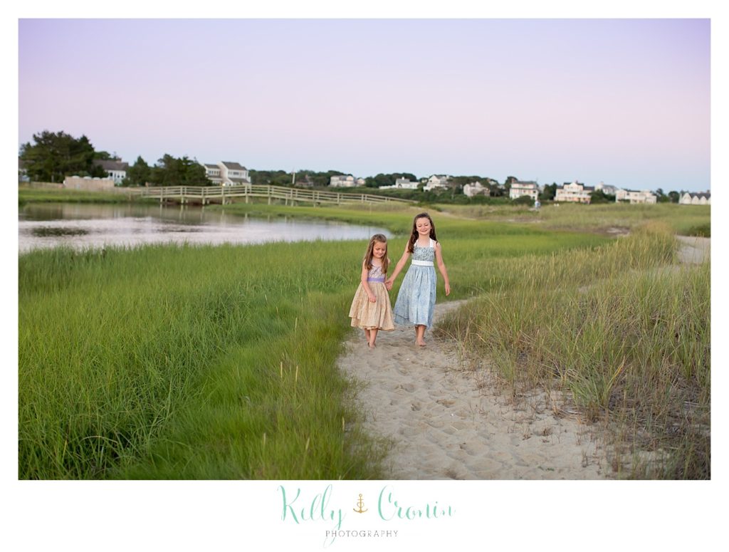 Two young sisters walk along a path on Ridgevale Beach. 