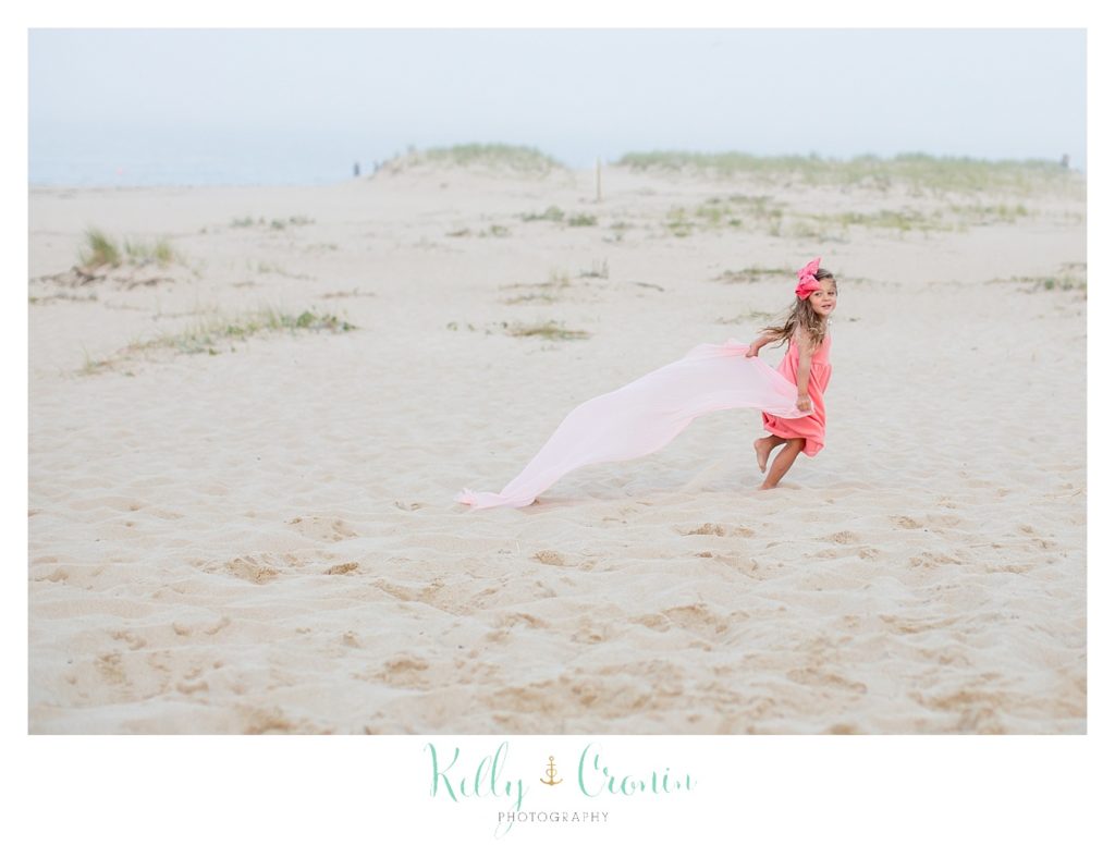 A young girl runs on the beach. 