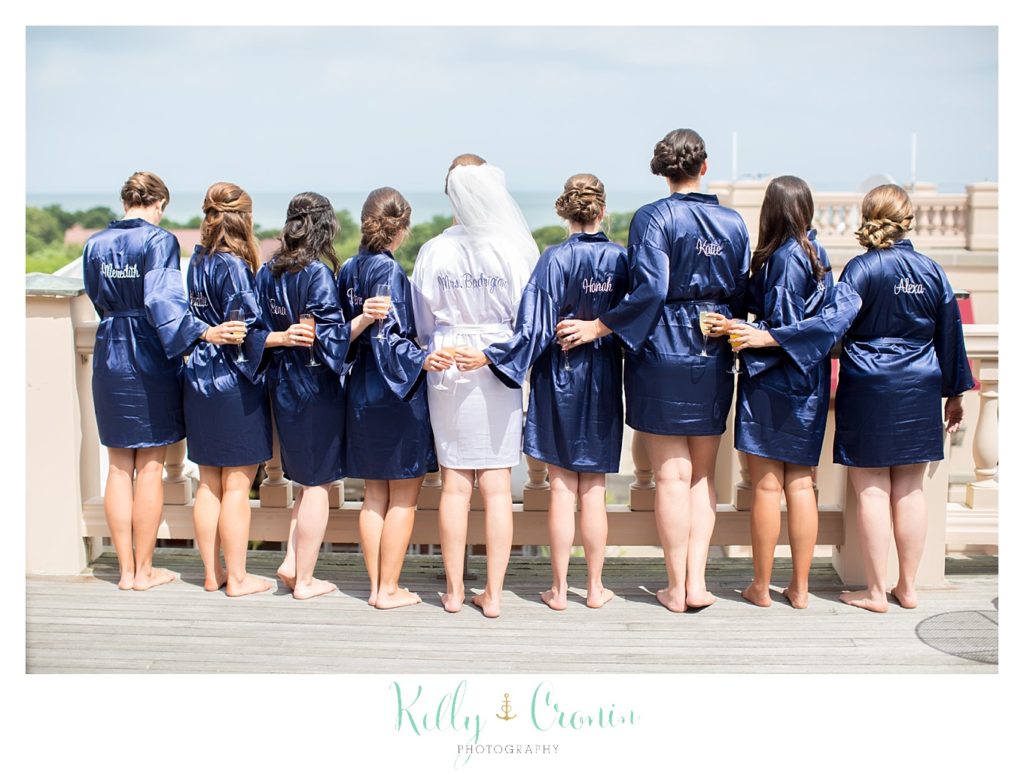 A bride and her bridal party stand in their robes. 