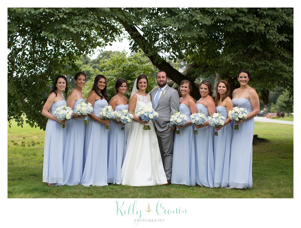 A bride stands with her bridal party. 