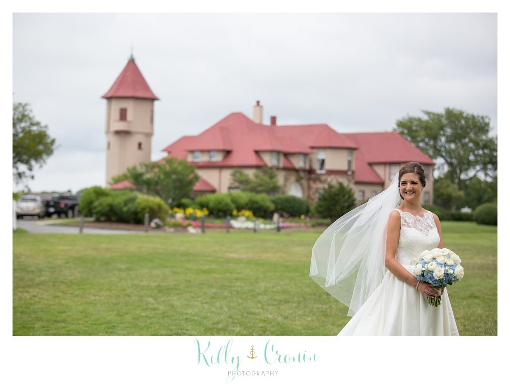 A bride stands in front of Ocean Edge Wedding facility. 