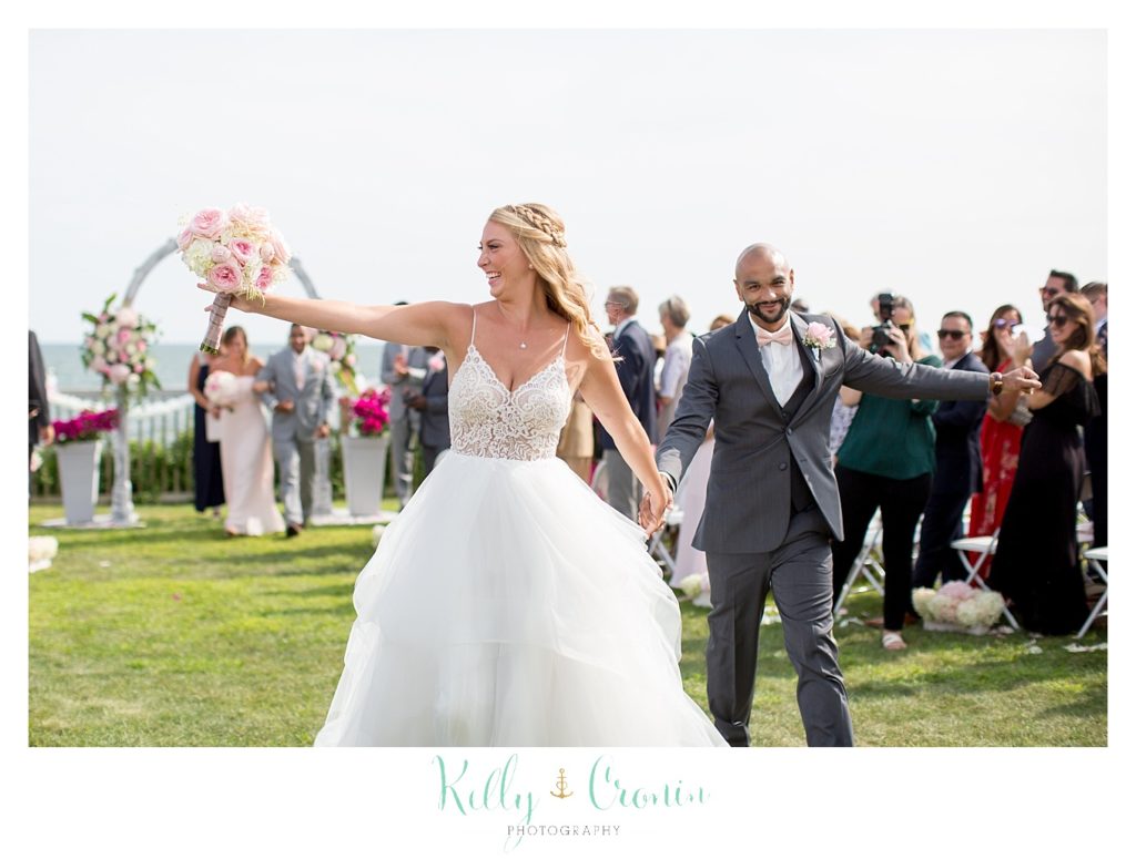 A woman tosses her bouquet at her wedding. 