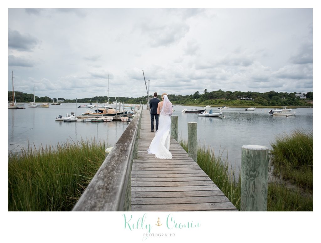 A bride stands on a pier.