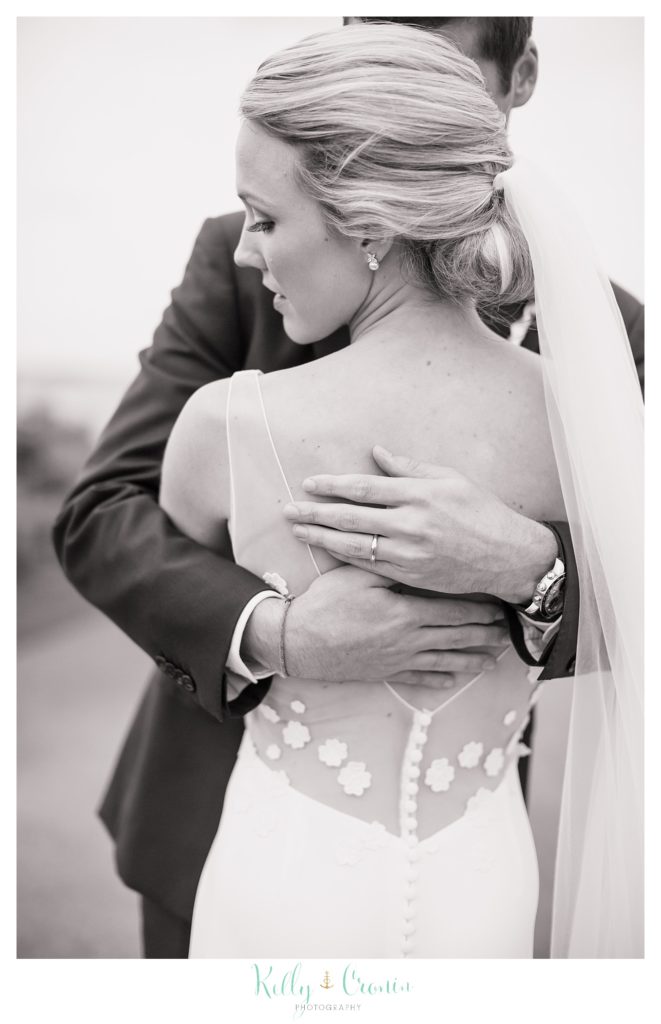 A man wraps his arms around his bride.