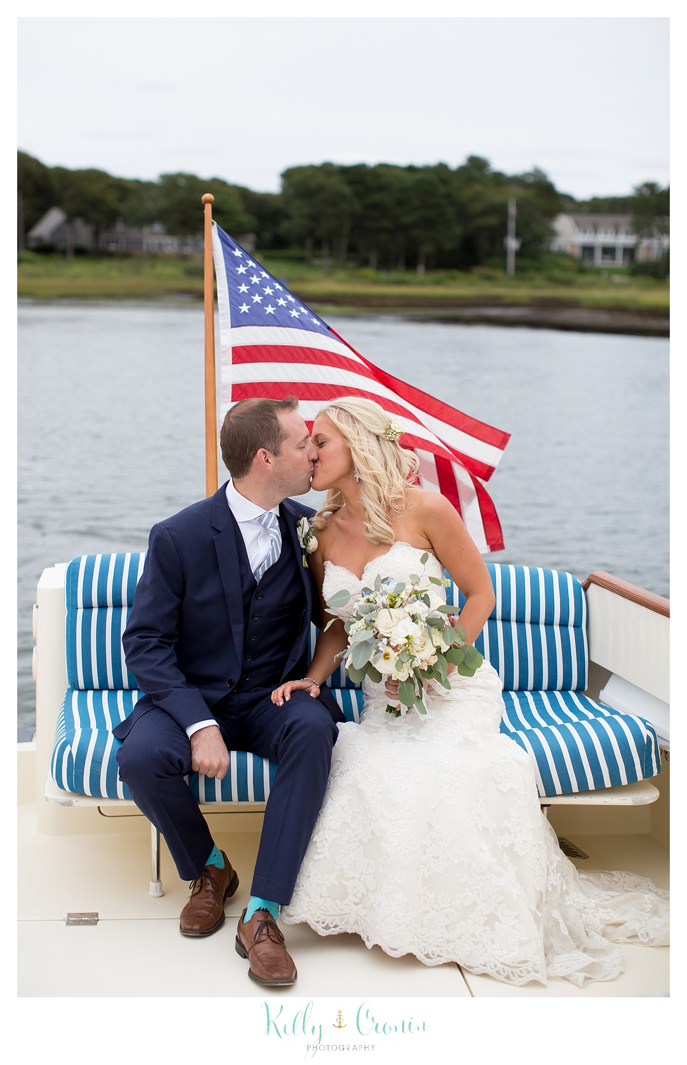 A bride and groom kiss on a boat.