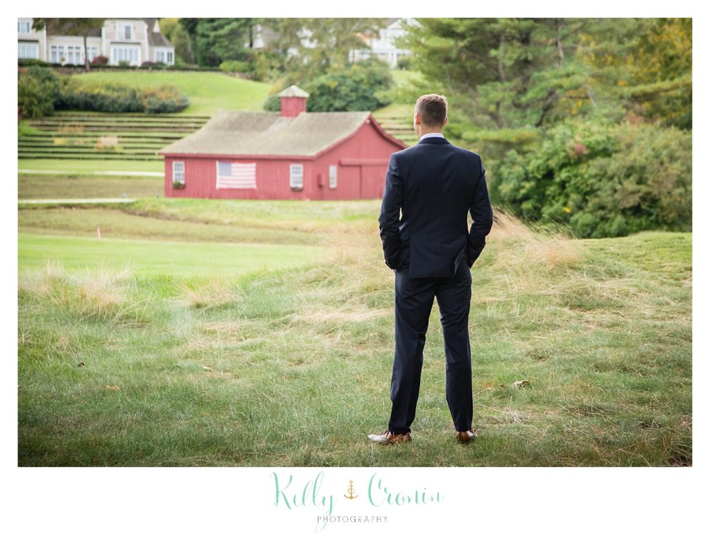 A groom stands waiting for his bride. 